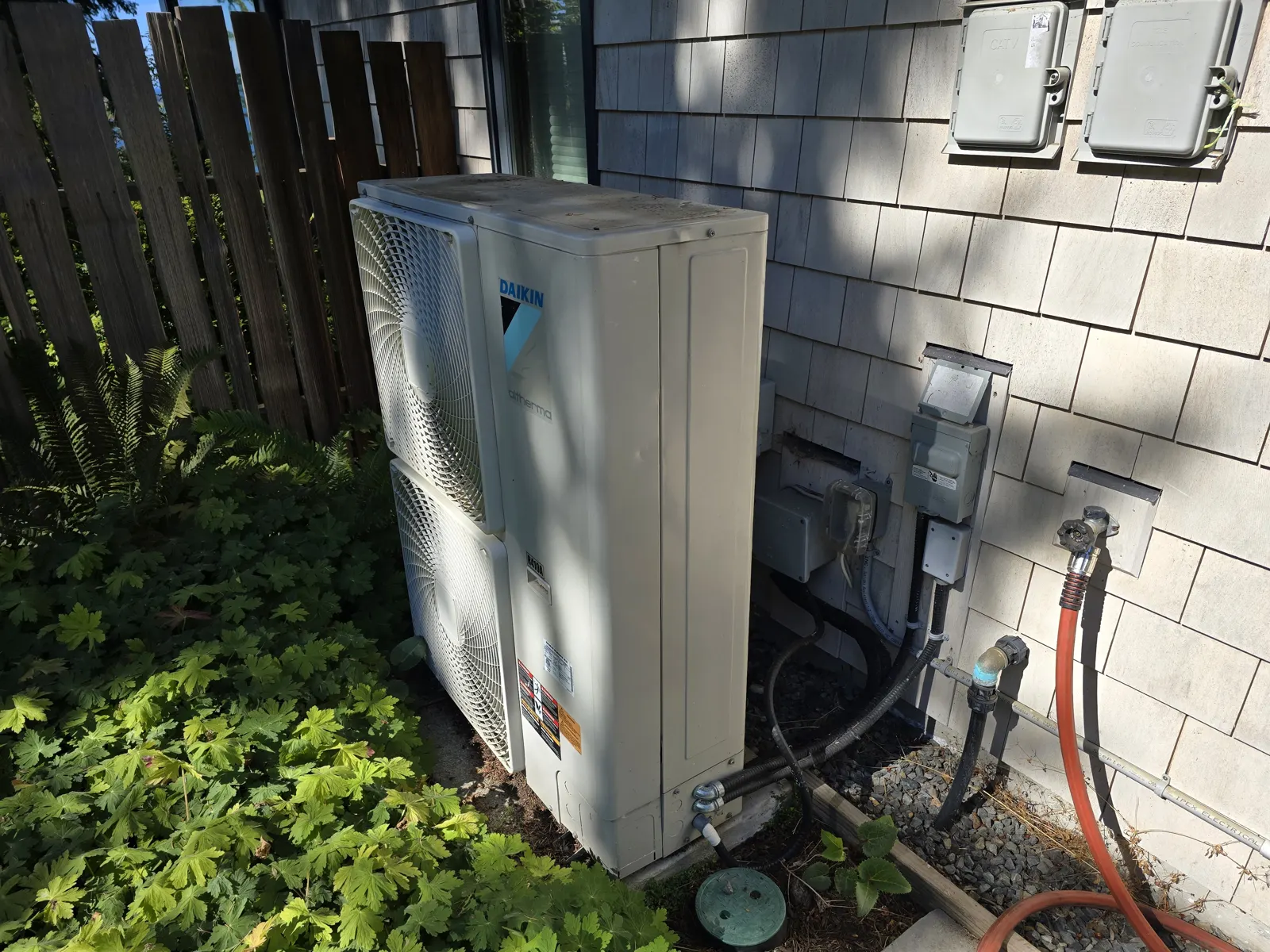 Before: Daikin Altherma outdoor unit against a shingle wall
