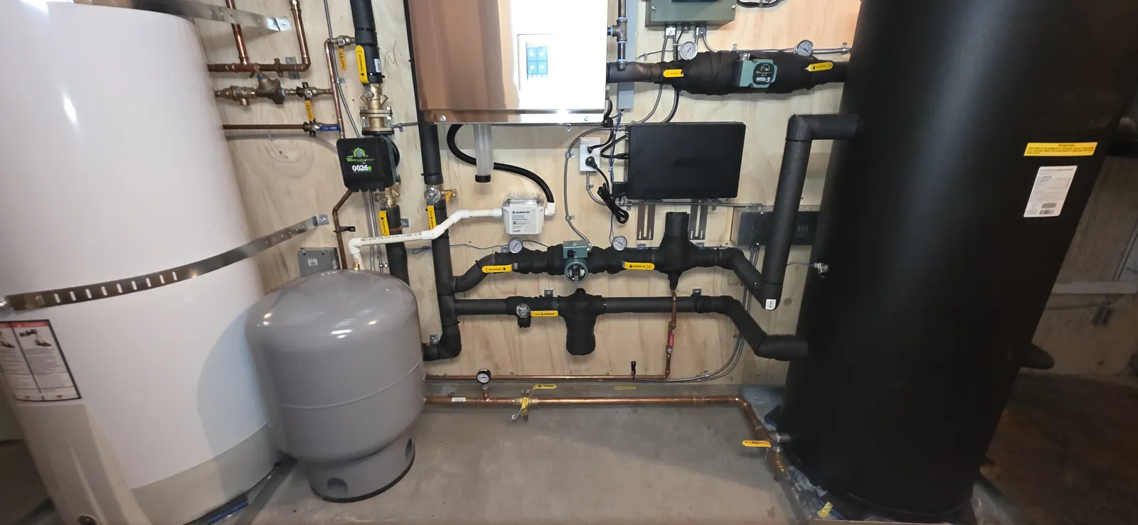 After: white hot water tank, expansion tank and black buffer tank with insulated piping