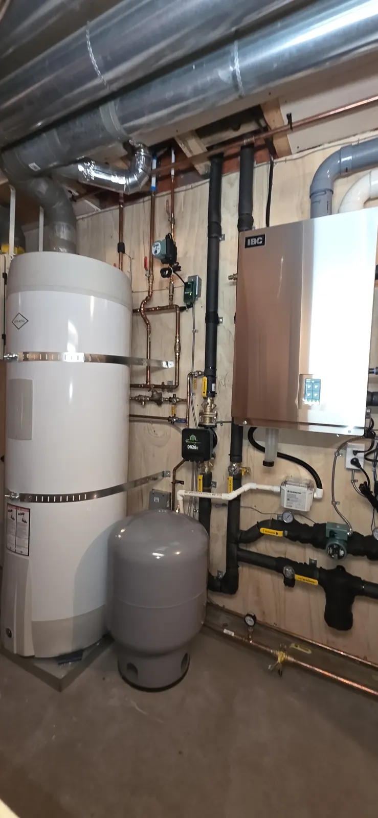 After: white hot water tank, expansion tank and new IBC boiler on a plywood panel
