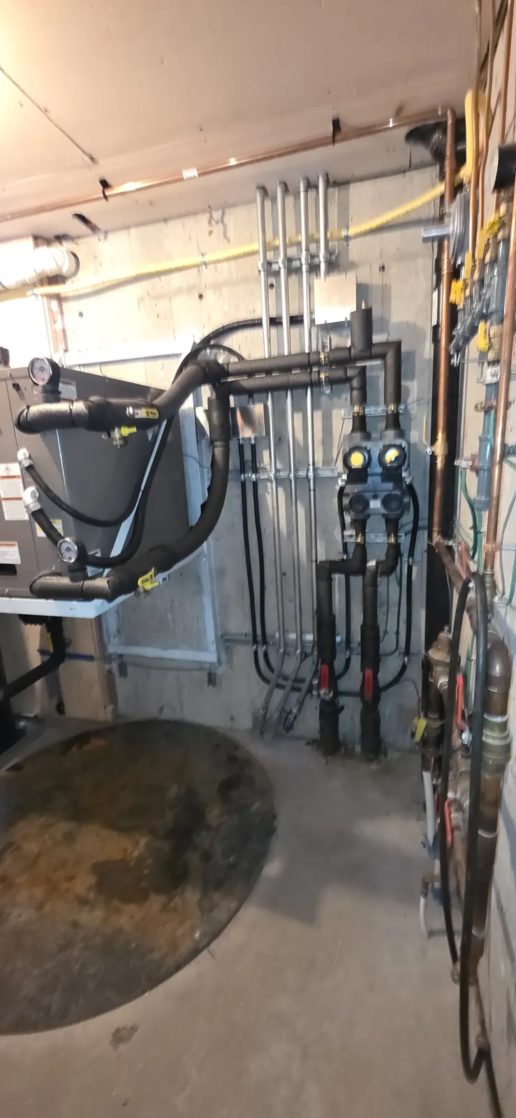 After: new GeoStar geothermal heat pump with insulated piping to the wall manifold