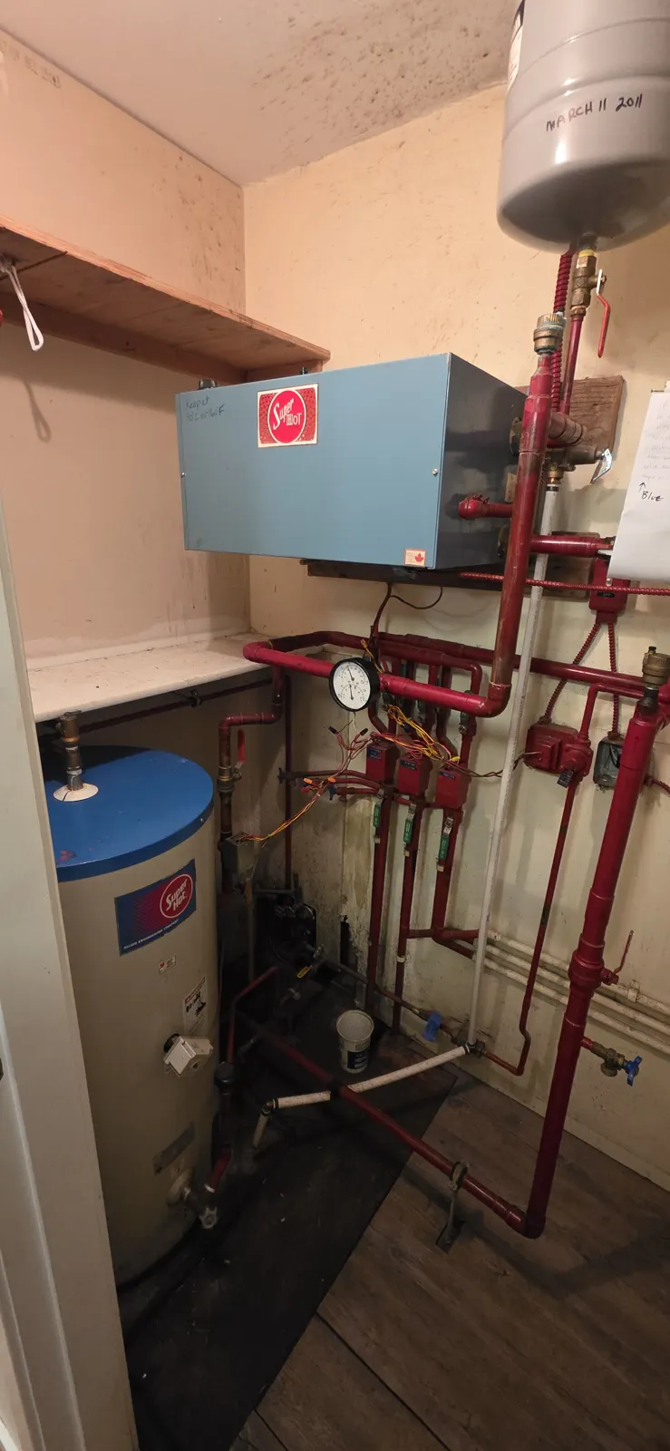 Before: the cramped closet with the old electric boiler and piping